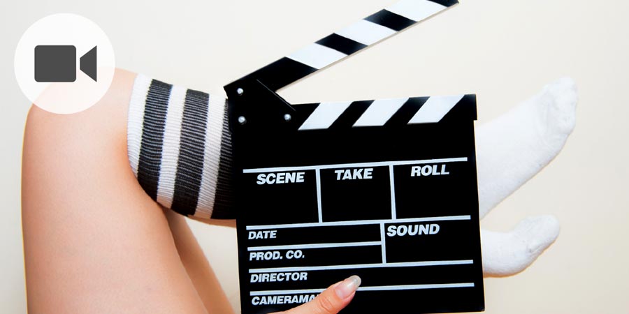 Erotically posed woman's legs and movie clapper board