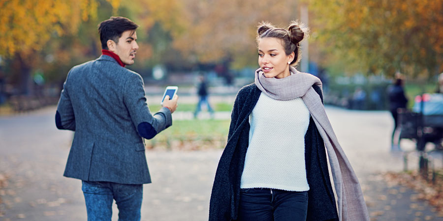 Handsome man walking through a park turning around because he was attracted to a beautiful woman