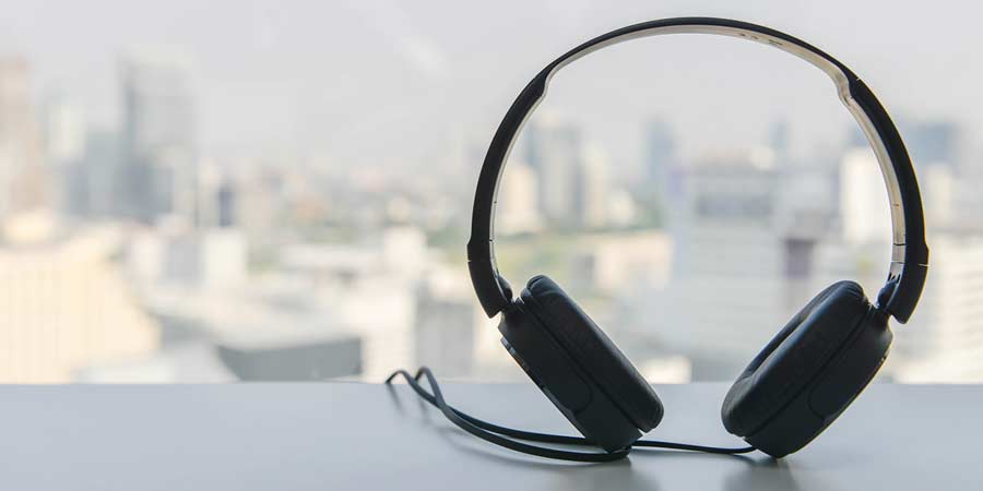 Headphones sitting on a ledge with a city landscape in the distance